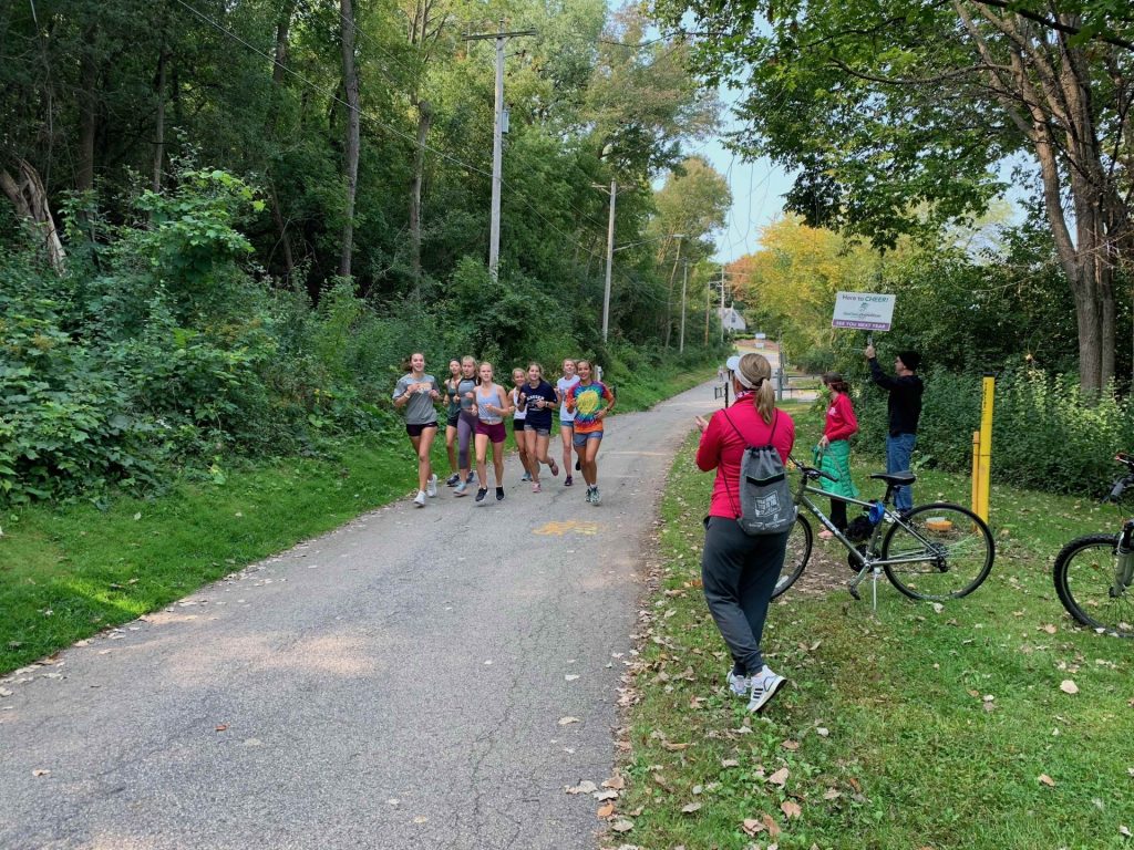 A high school cross country team gets a surprise along the Newberry Trail in Appleton from volunteers.