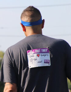 Brent M 9 months post surgery shows back of his shirt with Fox Cities Marathon bib.