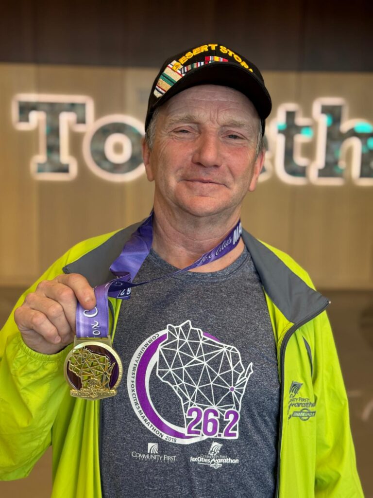 Fox Cities Marathon 35 Years Running legacy runner Basil Hansen holding medal.