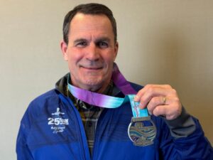 Fox Cities Marathon 35 years running legacy runner Stuart Kolb holding a medal.