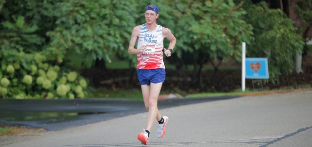 Fox Cities Marathon Competitive Walk Half Marathon, man waking along route with green trees.