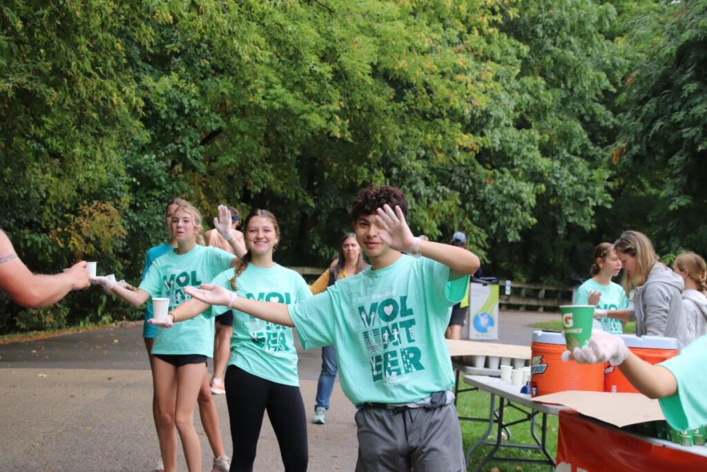 Fox Cities Marathon high school cross country program volunteers cheering.