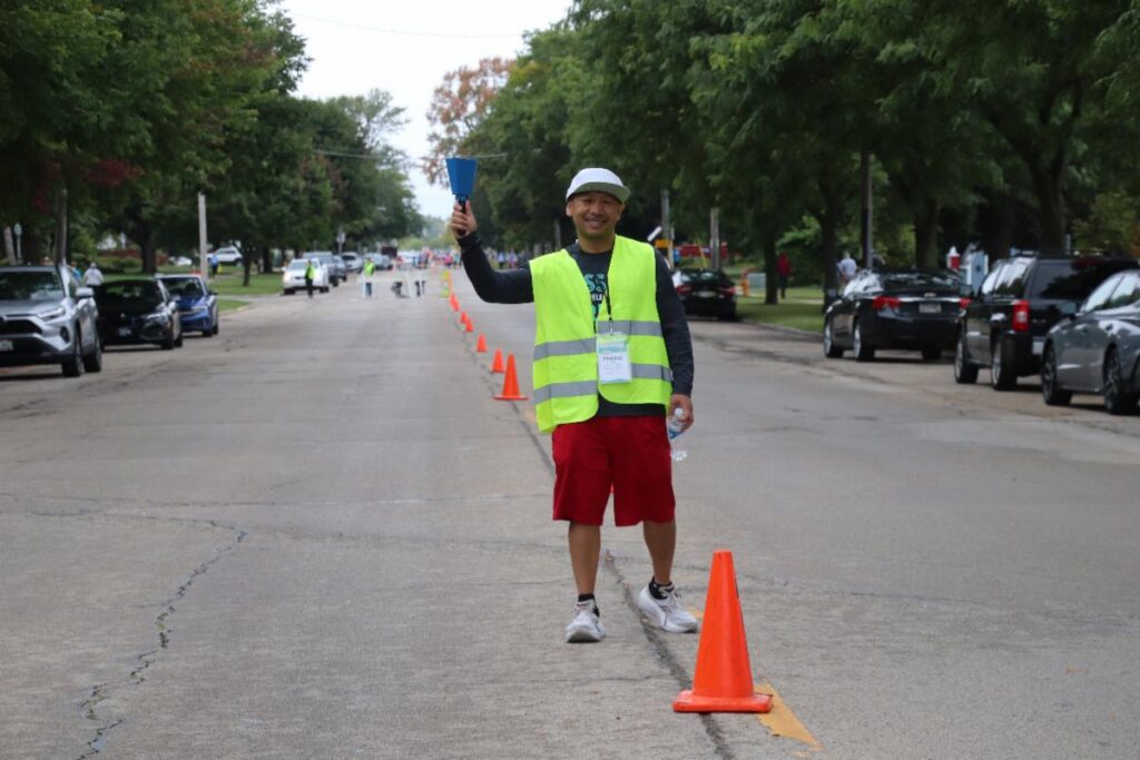 Fox Cities Marathon volunteer directing runners.