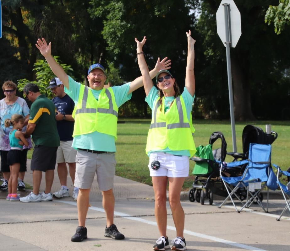 Fox Cities Marathon volunteers with arms raised.