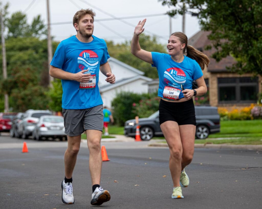 Fox Cities Marathon two people running and high fiving.