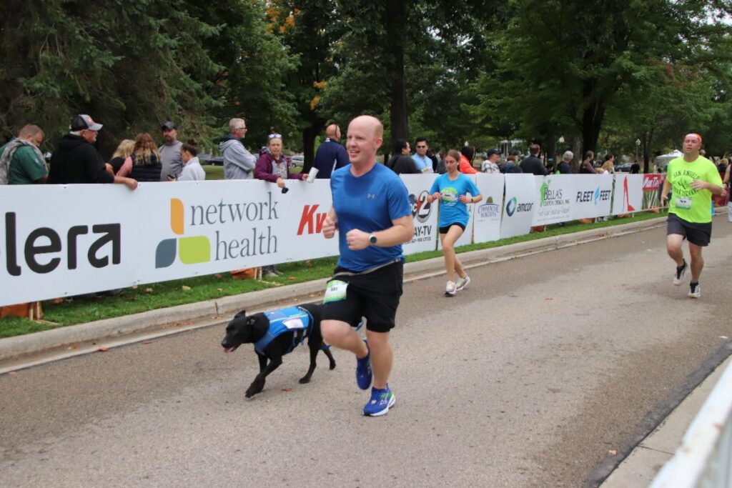 Fox Cities Marathon man running with dog.