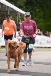 Fox Cities Marathon woman running with dog.